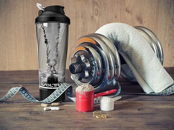 Rechargeable protein shaker beside dumbbells and towel
