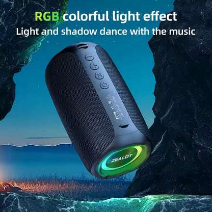 Black portable speaker with green LED light effect in a natural setting